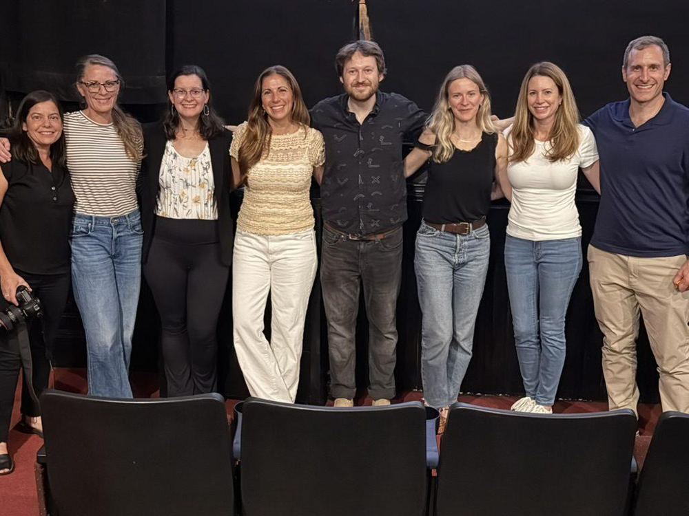 Ten people standing together on a stage after a film screening